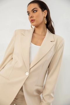 Bir model, Helin Avşar toptan giyim markasının HAV10011 - Retro Palazzo Jacket - Beige toptan Ceket ürününü sergiliyor.