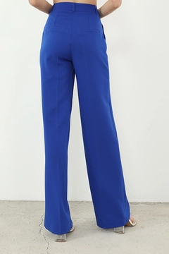 Bir model, Helin Avşar toptan giyim markasının HAV10019 - Retro Palazzo Trousers - Saks toptan Pantolon ürününü sergiliyor.