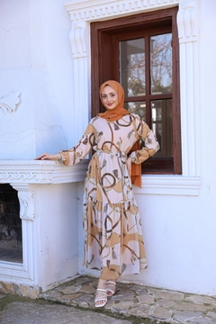 Bir model, Hulya Keser toptan giyim markasının HUL10102 - Helen Chain Dress - Mink toptan Elbise ürününü sergiliyor.