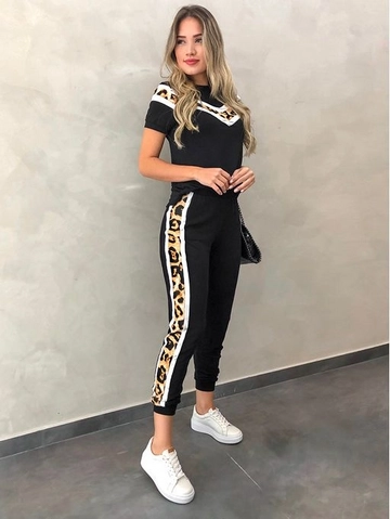 Bir model, Janes toptan giyim markasının  Üst V Leopar, Alt Yan şerit Leopar Detay Iki Iplik Kumaş Takım - Siyah
 toptan Takım ürününü sergiliyor.
