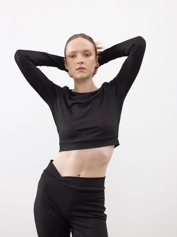 Bir model, Juste toptan giyim markasının  Fitilli Likralı Crop Uzun Kollu Bluz Siyah
 toptan Bluz ürününü sergiliyor.