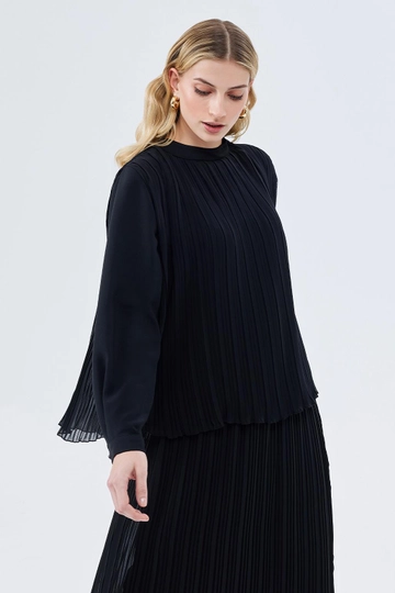 Bir model, Kadriye Baştürk toptan giyim markasının  Julia Pilise Detaylı Tunik Etek Siyah
 toptan Tunik ürününü sergiliyor.