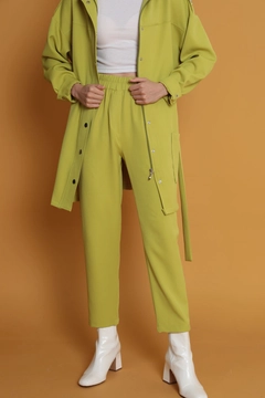 Bir model, Kaktus Moda toptan giyim markasının kam11686-atlas-fabric-women's-trousers-with-elastic-waist-oil-green toptan Pantolon ürününü sergiliyor.