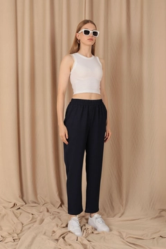Bir model, Kaktus Moda toptan giyim markasının kam11773-atlas-fabric-women's-trousers-with-elastic-waist-navy-blue toptan Pantolon ürününü sergiliyor.