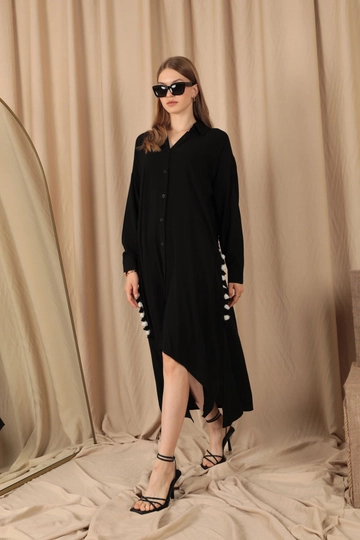 Bir model, Kaktus Moda toptan giyim markasının  Viskon Kumaş Püskül Detaylı Düğmeli Kadın Elbise - Siyah
 toptan Elbise ürününü sergiliyor.