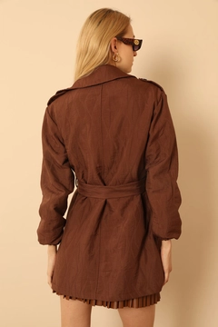 Bir model, Kaktus Moda toptan giyim markasının KAM10464 - Trench Coat - Brown toptan Trençkot ürününü sergiliyor.
