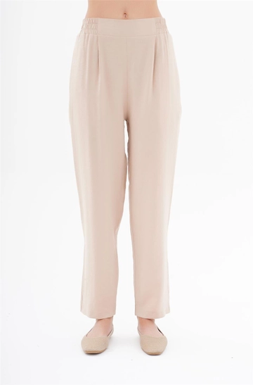 Bir model, Lefon toptan giyim markasının  Yanları Lastikli Bel Detaylı Havuç Pantolon - Bej
 toptan Pantolon ürününü sergiliyor.
