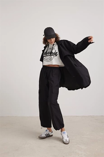 Una modelo de ropa al por mayor lleva  Pantalón De Mujer Con Detalle De Bolsillo De Paracaídas Negro
, Pantalón turco al por mayor de Levure
