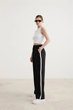 A wholesale clothing model wears lev10460-white-stripe-detailed-elastic-trousers-black, Turkish wholesale Pants of Levure