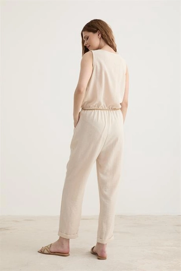 Bir model, Levure toptan giyim markasının  Kemer Detaylı Uzun Keten Tulum Taş
 toptan Tulum ürününü sergiliyor.