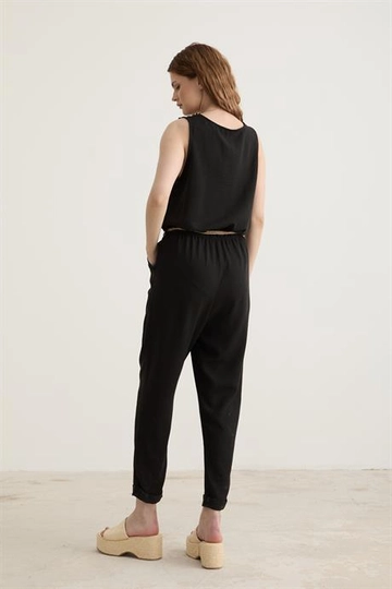 Bir model, Levure toptan giyim markasının  Kemer Detaylı Uzun Keten Tulum Siyah
 toptan Tulum ürününü sergiliyor.