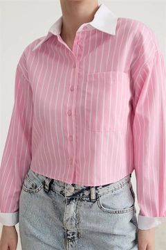 Bir model, Levure toptan giyim markasının 10450-garni-detailed-single-striped-crop-shirt-pink toptan Crop Top ürününü sergiliyor.