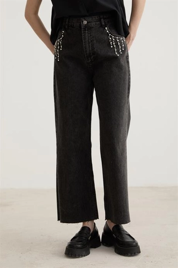 Bir model, Levure toptan giyim markasının  Taş Detaylı Paçası Püsküllü Kot Pantolon - Siyah
 toptan Kot Pantolon ürününü sergiliyor.