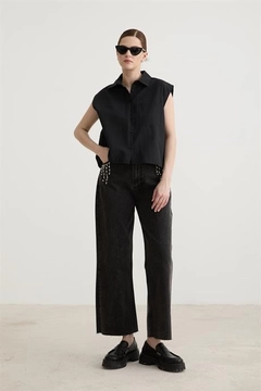 Bir model, Levure toptan giyim markasının lev10479-stone-detailed-tasseled-jeans-black toptan Kot Pantolon ürününü sergiliyor.