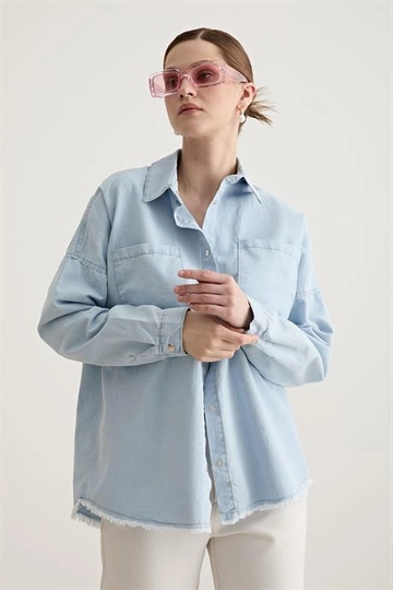 Bir model, Levure toptan giyim markasının  Etek Ucu Püskül Detaylı Oversize Kot Gömlek - Bebe Mavisi
 toptan Gömlek ürününü sergiliyor.