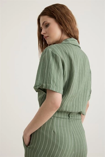 Bir model, Levure toptan giyim markasının  Toka Detaylı Düğmeli Uzun Tulum Çağla Yeşili
 toptan Tulum ürününü sergiliyor.