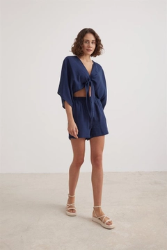 Bir model, Levure toptan giyim markasının lev10022-women's-muslin-tie-blouse-navy-blue toptan Crop Top ürününü sergiliyor.