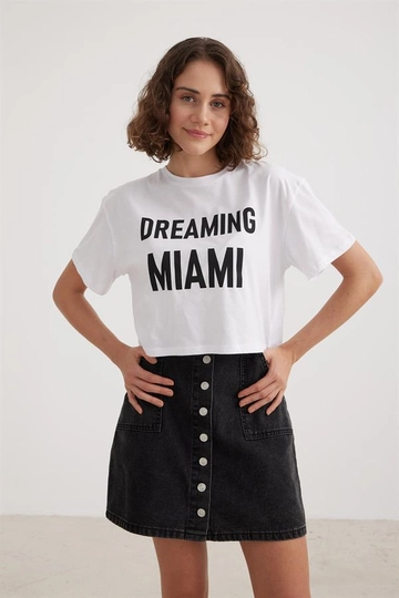 Bir model, Levure toptan giyim markasının  Kadın Crop Yazılı Tshirt Beyaz
 toptan Tişört ürününü sergiliyor.