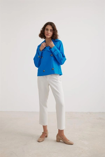 Bir model, Levure toptan giyim markasının  Kadın Kısa Trençkot Saks
 toptan Trençkot ürününü sergiliyor.