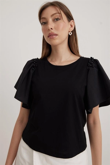 Bir model, Levure toptan giyim markasının  Kol Volanlı Kadın Tshirt Siyah
 toptan Tişört ürününü sergiliyor.