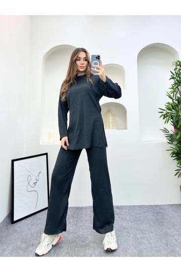 Bir model, Maxi Modena toptan giyim markasının  Üst Yırtmaçlı Bluz Alt Palazzo Fitilli Takım
 toptan Takım ürününü sergiliyor.