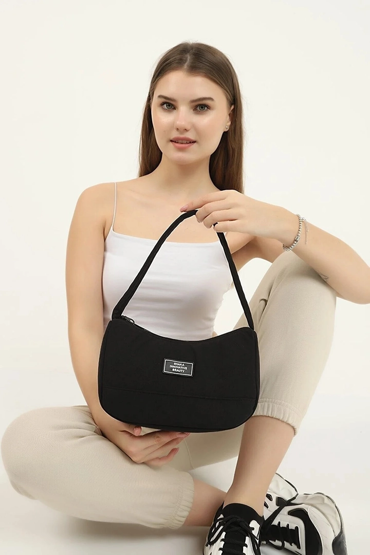 A wholesale clothing model wears mna10658-daily-sports-baguette-canvas-fabric-hand-and-shoulder-bag-with-single-zipper-compartment, Turkish wholesale Bag of Mina Fashion