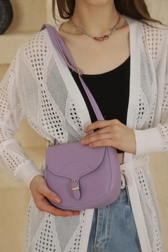 A wholesale clothing model wears mna10824-simple-and-stylish-snap-closure-crossbody-shoulder-bag-with-adjustable-strap, Turkish wholesale Bag of Mina Fashion