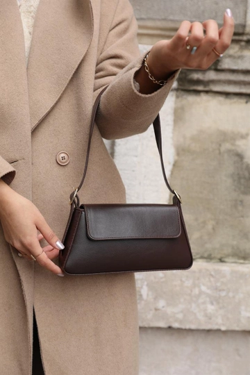 Bir model, Mina Fashion toptan giyim markasının  Alba Sade Tasarım Kapaklı  Kol Çantası - Kahverengi
 toptan Çanta ürününü sergiliyor.
