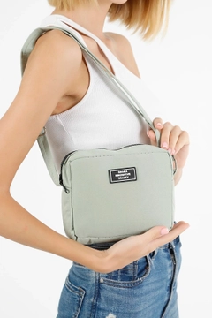 A wholesale clothing model wears mna10125-canvas-fabric-shoulder-bag-with-single-zipper-compartment-and-adjustable-strap, Turkish wholesale Bag of Mina Fashion