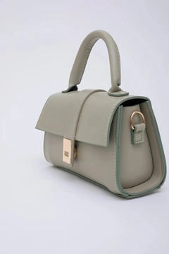 A wholesale clothing model wears mna11385-faux-leather-women's-handbag-and-shoulder-bag-with-adjustable-strap-with-snap-fasteners, Turkish wholesale Bag of Mina Fashion