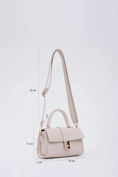 A wholesale clothing model wears mna11387-faux-leather-women's-handbag-and-shoulder-bag-with-adjustable-strap-with-snap-fasteners, Turkish wholesale Bag of Mina Fashion
