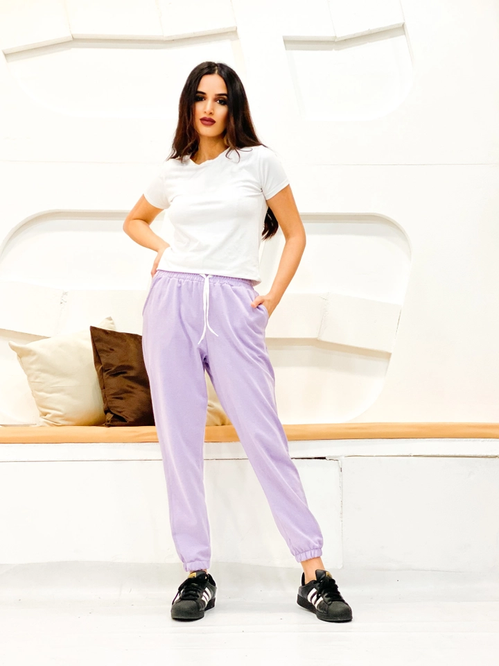 Bir model, Miyalon toptan giyim markasının 35774 - Sweatpants - Lilac toptan Eşofman Altı ürününü sergiliyor.