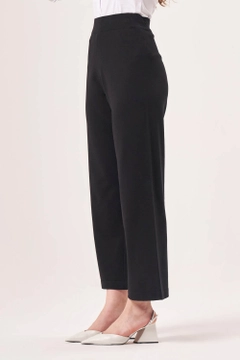 Bir model, Mizalle toptan giyim markasının MZL10247 - Pants - Black toptan Pantolon ürününü sergiliyor.