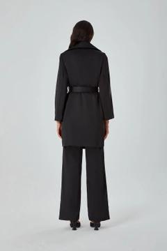 Bir model, Mizalle toptan giyim markasının 26557 - Trenchcoat - Black toptan Trençkot ürününü sergiliyor.