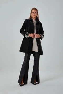 Bir model, Mizalle toptan giyim markasının 34042 - Trenchcoat - Black toptan Trençkot ürününü sergiliyor.