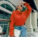 Bir model,  toptan giyim markasının 39401-sweater-orange toptan  ürününü sergiliyor.