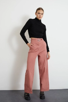 Bir model, Newgirl toptan giyim markasının new10009-gabardine-fabric-buckle-belt-wide-leg-women's-trousers-dusty-rose toptan Pantolon ürününü sergiliyor.