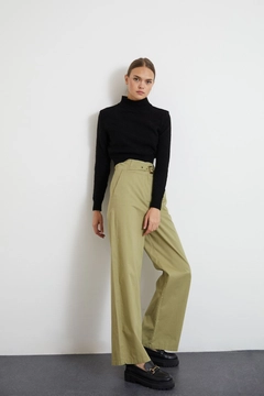 Bir model, Newgirl toptan giyim markasının new10054-gabardine-fabric-buckle-belt-wide-leg-women's-trousers-khaki toptan Pantolon ürününü sergiliyor.