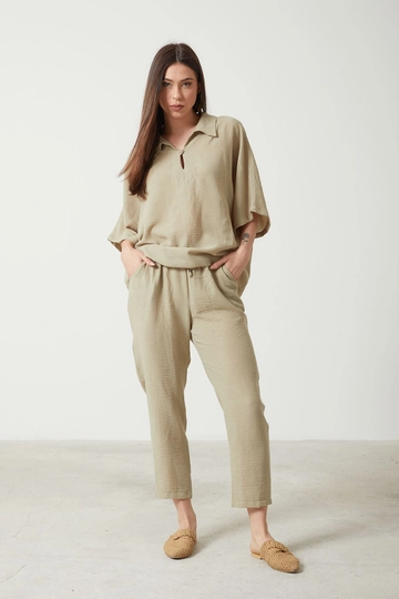 Bir model, Newgirl toptan giyim markasının  Gömlek Yaka Üst Lastik Bel Pantolon Kadın Yazlık Takım - Haki
 toptan Takım ürününü sergiliyor.