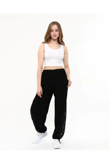 Bir model, Newgirl toptan giyim markasının  Viskon Kumaş Dantel Paça Bel Lastik Kadın Şalvar Pantolon - Siyah
 toptan Pantolon ürününü sergiliyor.