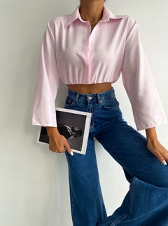 Bir model, Radica Fashion toptan giyim markasının raf10034-pink-sleeve-detailed-crop-shirt toptan Crop Top ürününü sergiliyor.