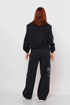Bir model, Reyon toptan giyim markasının rey11782-striped-trousers-with-cargo-pockets-navy-blue toptan Pantolon ürününü sergiliyor.
