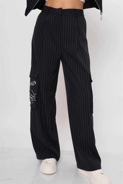 Bir model, Reyon toptan giyim markasının rey11782-striped-trousers-with-cargo-pockets-navy-blue toptan Pantolon ürününü sergiliyor.