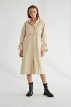Bir model, Robin toptan giyim markasının 3360 - Stone Trenchcoat toptan Trençkot ürününü sergiliyor.