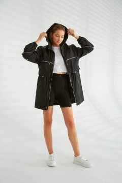 Bir model, Robin toptan giyim markasının 21322 - Trenchcoat - Black toptan Trençkot ürününü sergiliyor.