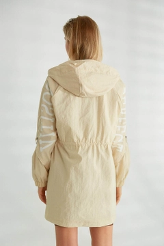 Bir model, Robin toptan giyim markasının 21323 - Trenchcoat - Stone toptan Trençkot ürününü sergiliyor.