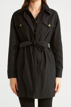 Bir model, Robin toptan giyim markasının 32090 - Trenchcoat - Black toptan Trençkot ürününü sergiliyor.