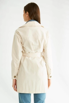 Bir model, Robin toptan giyim markasının 32092 - Trenchcoat - Stone toptan Trençkot ürününü sergiliyor.