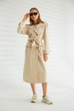 Bir model, Robin toptan giyim markasının 44346 - Trench Coat - Stone Color toptan Trençkot ürününü sergiliyor.