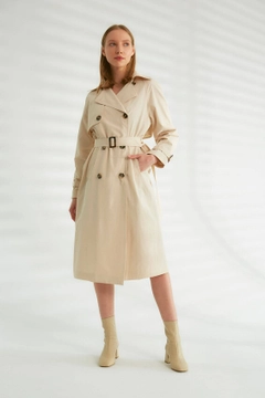 Bir model, Robin toptan giyim markasının 44340 - Trench Coat - Light Stone Color toptan Trençkot ürününü sergiliyor.